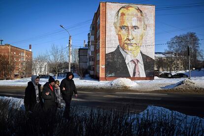 Unos peatones pasan junto a un mural del presidente ruso, Vladímir Putin, en un edificio residencial de la localidad de Kashira (Rusia).