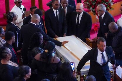 Andre Zachery, father of Jordan Neely places his hand on Neely's casket, after a funeral service at Harlem's Mount Neboh Baptist Church