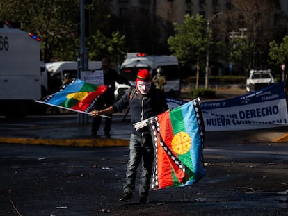 Un hombre sostiene banderas del pueblo mapuche durante una protesta en Santiago, en septiembre de 2022.
