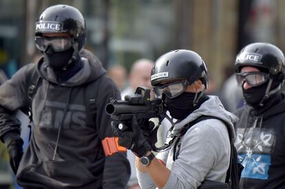 Un policía apunta con su arma para lanzar gas lacrimógeno durante los enfrentamientos con los manifestantes en Nantes.