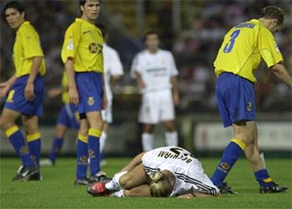 Riquelme y Roger observan a Beckham, sobre el césped, que se duele de un golpe de Arruabarrena (derecha).