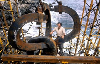 El escultor vasco Eduardo Chillida en el montaje de su obra 'El peine de los vientos', al pie del monte Igueldo de San Sebastián, el lunes 15 de agosto de 1977. La escultura, que está compuesta por tres piezas de acero de diez toneladas cada una, colocadas sobre las rocas al final del paseo Ondarreta, se han convertido en un símbolo de la capital donostiarra. Durante los años cincuenta Eduardo Chillida se hizo conocido internacionalmente y empezó a exponer en París, Nueva York, Chicago, Venecia, donde recibió en 1958 el Gran Premio lnternacional de Escultura, el primero de una larga lista de reconocimientos.