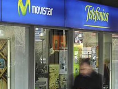 Varios peatones caminan ante una tienda de Telefónica en España