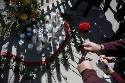 Personas colocan flores y velas a modo de homenaje a los fallecidos en la puerta del centro del INM de Ciudad Juárez, este 28 de marzo.