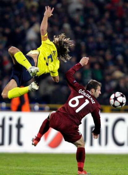 Puyol pelea por el balón con Gökdeniz.