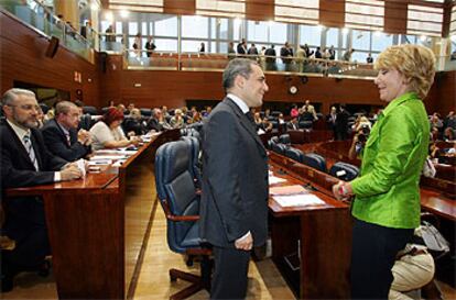 Esperanza Aguirre conversa en el hemiciclo con el portavoz socialista, Rafael Simancas, ante la atenta mirada de Fausto Fernández, de IU, a la izquierda de la foto.