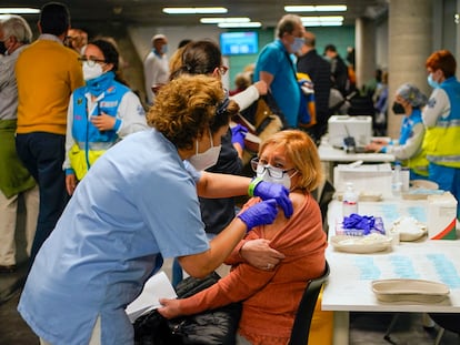 Una sanitaria inocula la vacuna de AstraZeneca a una madrileña en el WiZink Center de Madrid.