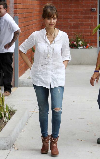 Jessica Alba aprueba raspando con un look a base de básicos: camisa blanca, jeans y botas de aire cowboy.