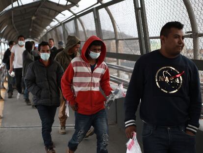 Migrantes centroamericanos usan mascarillas protectoras al cruzar la frontera entre México y Estados Unidos, el pasado 21 de marzo.