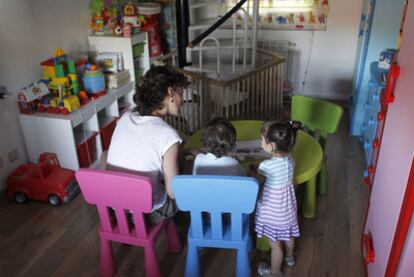 Beatriz Rubio juega con sus mellizos en una habitación de su casa.