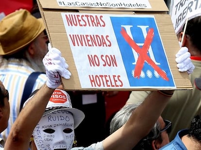 Un hombre sostiene un cartel bajo el lema "Stop pisos turísticos" durante la manifestación del Primero de Mayo en Madrid.