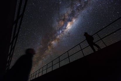 Duas pessoas observam a Via Láctea no monte Paranal (Chile).