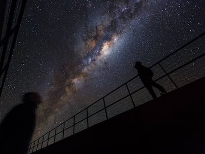 Duas pessoas observam a Via Láctea no monte Paranal (Chile).