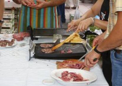 Unas personas cocinan carne de caballo. EFE/Archivo