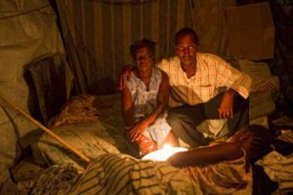 Un médico y su madre atienden a una enferma de malaria en Haití.