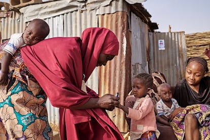La trabajadora de la salud Hafsat Mikauli, que administra vacunas de la polio, marcaba el dedo de una niña inmunizada con un rotulador en Makurdi Gagi (Estado de Sokoto, Nigeria), el 29 de febrero de este año. Mikauli, de 30 años y madre de cuatro hijos, explica a las comunidades los beneficios de la vacunación, a menudo usando a su bebé de un año como ejemplo de la importancia de prevenir enfermedades.  