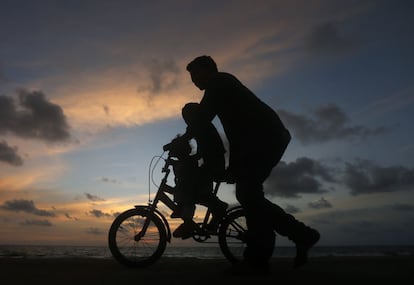 Un hombre empuja la bicicleta de su hijo en Colombo (Sri Lanka), el 5 de noviembre de 2014.