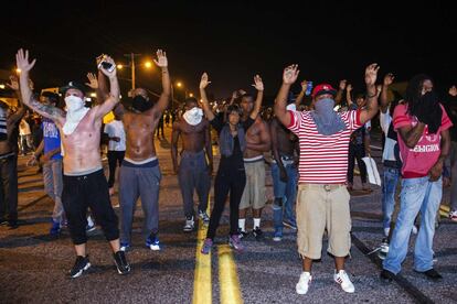 Los manifestantes alzan sus manos como protesta por el asesinato del joven negro Michael Brown el sábado 9 de agosto.