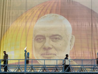 Unos trabajadores colocan un cartel gigante con el retrato de Ismail Haniya, este miércoles en Teherán.