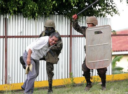 Los agentes han intentado disolver varios piquetes que interrumpían el acceso a la sede de Gobierno. En la imagen, dos soldados golpean a un simpatizante de Manuel Zelaya.