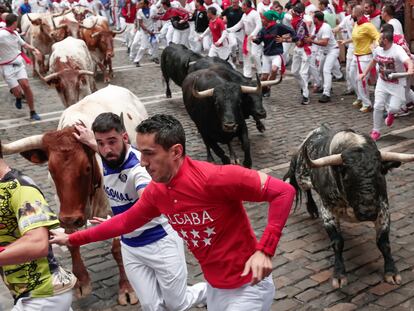 Varios mozos corren delante de la manada de Victoriano del Río en el tercer encierro de los Sanfermines este martes, en Pamplona.