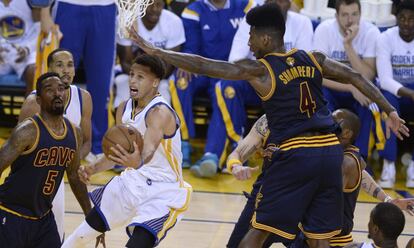 Curry, con el bal&oacute;n, entre JR Smith y Shumpert.