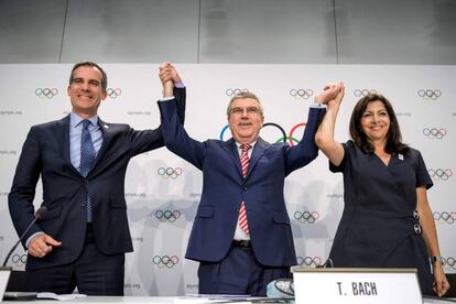 Thomas Bach, presidente del COI, levanta los brazos de Eric Garcetti, alcalde de Los &Aacute;ngeles, y de Anne Hidalgo, alcaldesa de Par&iacute;s.