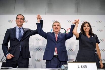 Thomas Bach, presidente del COI, levanta los brazos de Eric Garcetti, alcalde de Los Ángeles, y de Anne Hidalgo, alcaldesa de París.