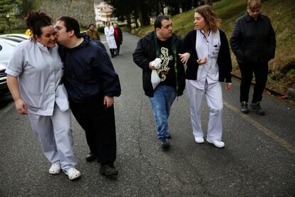 Iñaki Gorriz (izquierda) besa a una de las trabajadoras sociales, mientras Andrés García (centro) camina con una de las enfermeras durante un paseo con Argi y Atila, los dos galgos que participan en el programa.
