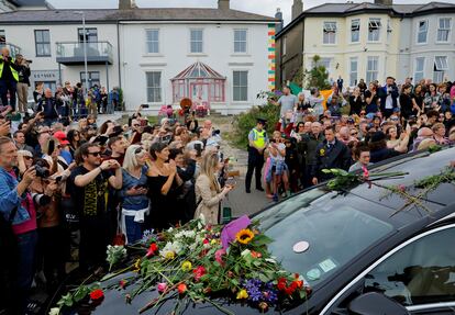 A hearse carrying the coffin of late Irish singer Sinead O'Connor passes outside her former home during her funeral procession as fans line the street to say their last goodbye to her, in Bray, Ireland, August 8, 2023.