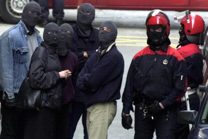 Varios <i>ertzainas</i> ocultan sus rostros con pasamontañas durante una operación antiterrorista en 2001.