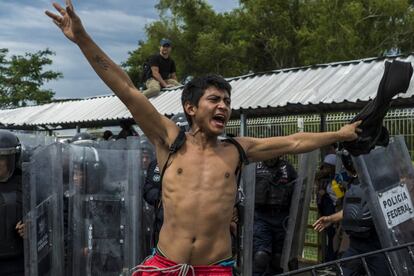 Un joven grita pidiendo calma durante el enfrentamiento con la policía en el puente que divide México y Guatemala.