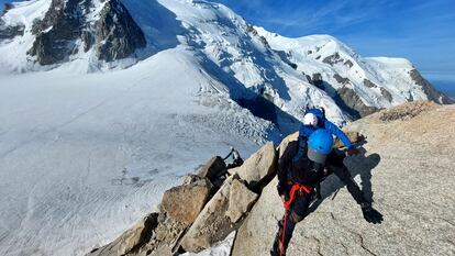 Una cordada escala con ladera del Mont Blanc de Tacul de fondo, a la izquierda de la imagen, entre sol y sombra.