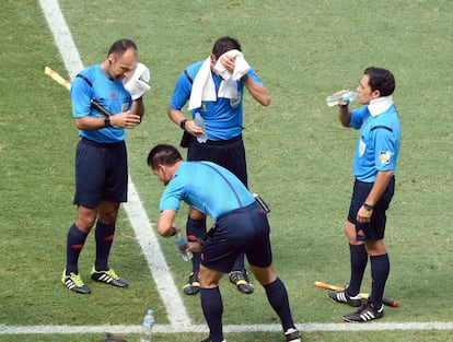 El equipo arbitral se refresca durante un 'cooling break'.