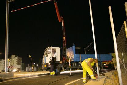 Operarios trabajando de noche para instalar las señales de tráfico del nuevo puente.