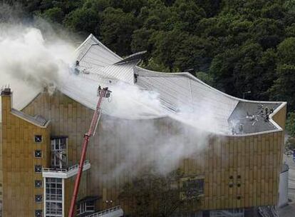 El humo sale por el tejado del edificio de la sede de la Filarmónica de Berlín mientras los bomberos luchan por extinguir el fuego.
