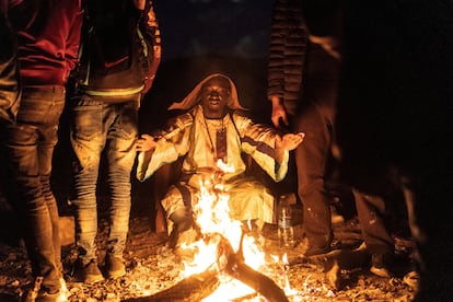Un migrante senegalés se calienta junto a una fogota, tras ser detenido por las autoridades migratorias en Lukeville.