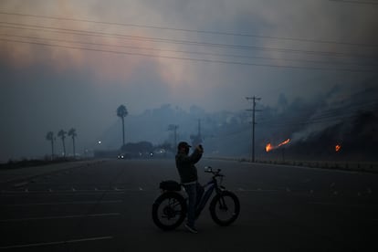 Un hombre toma fotos del incendio en la zona de Palisades.