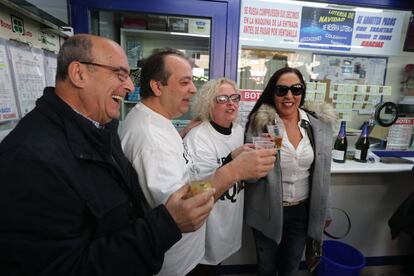 Dos ganadores del Gordo de Navidad (1 i. y 1 d.) junto a los dueños de la administración situada en el Paseo de la Esperanza, número 4, en Madrid, celebran la venta íntegra del número 66.513, agraciado con el Gord ode Navidad.