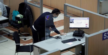 Un hombre desinfecta uno de los puestos dela sede de la delegación de Hacienda de Guzmán el Bueno en Madrid. 