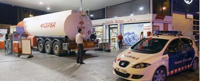 Los Mossos d'Escuadra custodian un camión cisterna que abastece a una gasolinera en Barcelona.