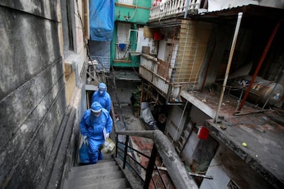 Trabajadores sanitarios protegidos contra el coronavirus en un edificio en Hanoi (Vietnam).