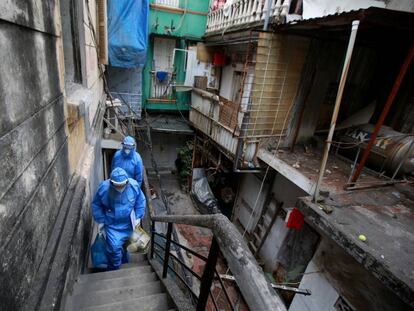 Trabajadores sanitarios protegidos contra el coronavirus en un edificio en Hanoi (Vietnam).