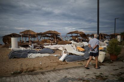 Un hombre pasea junto a varias sombrillas y hamacas en una playa afectada por las tormentas.