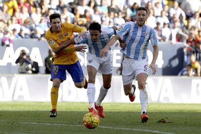  El delantero argentino del FC Barcelona Leo Messi (i) disputa un balón con el centrocampista del Málaga Ignacio Camacho (d) y el defensa brasileño Weligton Robson (c).