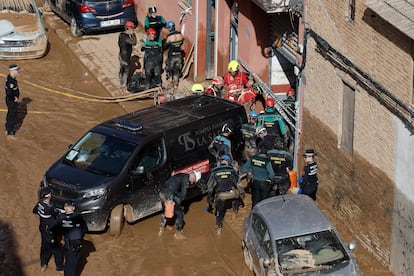 Guardias civiles y policías locales acceden al interior de un garaje en el barrio valenciano de La Torre, en búsqueda de posibles fallecidos, este jueves. 