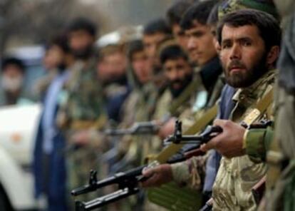 Una fila de hombres armados aguarda la conclusión de la toma de posesión de Karzai, celebrada el sábado.