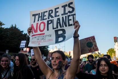 A young woman holds up a sign during a protest march, warning about the dangers of climate change, in Madrid, on September 27, 2019.