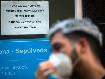 Una persona con mascarilla hace cola en una Oficina de Trabajo, en Barcelona, el 7 de agosto.