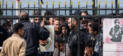 Migrantes esperan a ser atendidos por oficiales turcos, en Esmirna (Turquía).